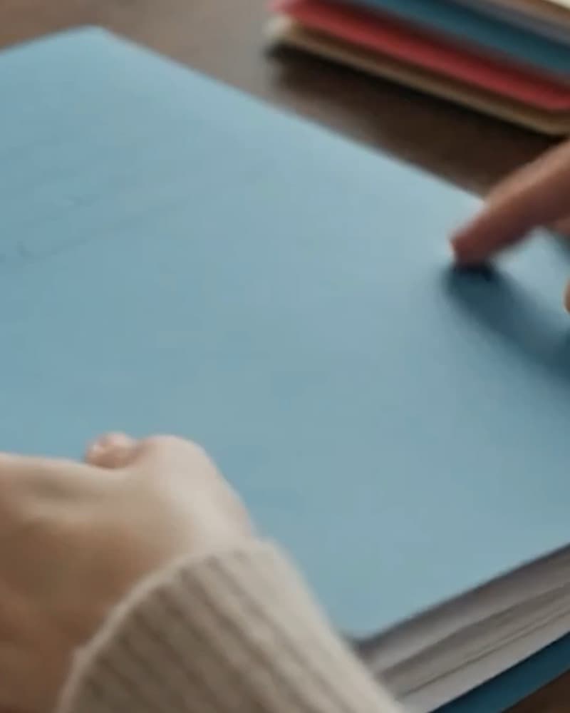 Hands resting on a stack of client folders